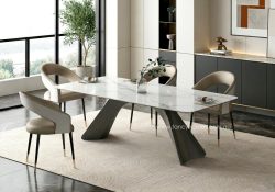 Top view of Fancy Homes modern large-scale Archway dining table featuring a cream-veined sintered stone top and a sculptural grey-bronze carbon steel base with a Nano-oil brushed finish, set in a bright minimalist dining room.